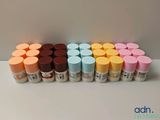 un gros plan sur un assortiment de pots de peinture de différentes couleurs posés sur une table