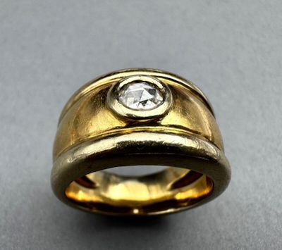 a close up of a gold ring with a diamond in the center