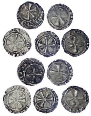 six pièces d'argent sont disposées en cercle sur une surface blanche