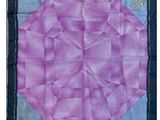 un gros plan sur une couette violette et bleue ornée d'une fleur
