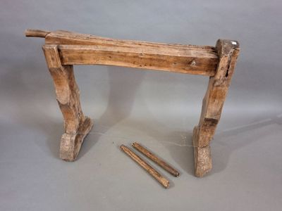 a piece of wood that is sitting next to a pair of nails