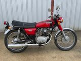 une moto rouge garée devant un immeuble