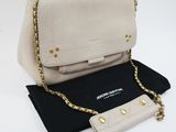 a white and black purse sitting on top of a black cloth