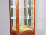 une vitrine ancienne avec des étagères en verre et un socle en bois