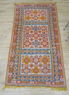 un tapis orange et bleu posé sur un parquet