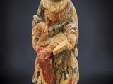 une statue ancienne d'une femme tenant un bébé dans ses bras
