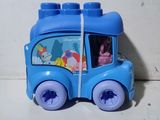 un petit bus jouet bleu avec une petite fille à l'intérieur