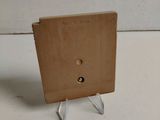 a small wooden box with a hole in it