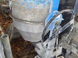 une bétonnière posée à côté d'un tas de ferraille