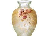 un vase en verre orné d'une fleur, posé sur une surface blanche