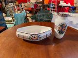 two vases and a bowl on a table in a store