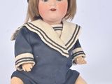 a doll that is sitting on the ground wearing a hat