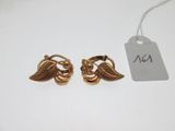 a pair of gold earrings with leaves on them