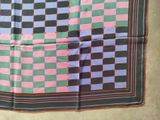 a close up of a square scarf with a checkered pattern on it