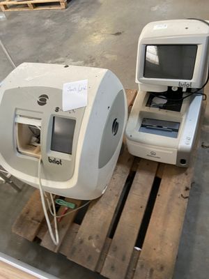 two computers sitting on a pallet in a warehouse