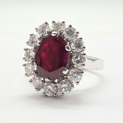 une bague ovale sertie d'un rubis et de diamants, entourée d'un bouquet de diamants blancs
