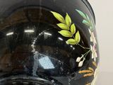 a black vase with a floral design on it