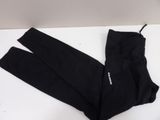 the pair of black pants are laying on a white surface