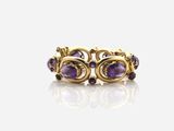 un gros plan d'une bague en or sertie de pierres violettes