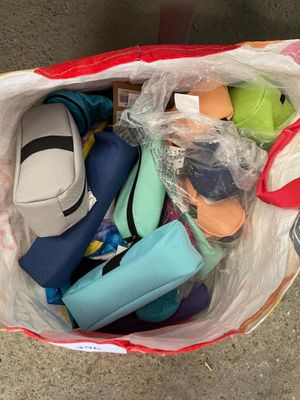 un sac en plastique rempli de divers objets, posé par terre
