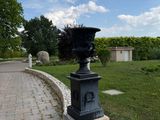 a black vase sitting on top of a stone pillar