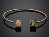 un bracelet manchette en or orné de pierres vertes et roses