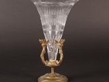 an antique glass vase with gold accents on a black background