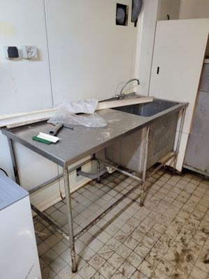 une cuisine avec un évier et un réfrigérateur