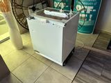a white dishwasher sitting on the floor in a kitchen