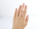 a woman ' s hand with a gold ring on it