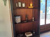 une bibliothèque en bois avec des livres dessus, dans un salon