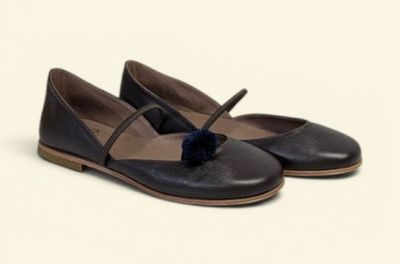 the shoes are black and brown with a blue pom pom on the toe