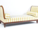 une chaise longue rayée jaune et blanche devant un mur blanc