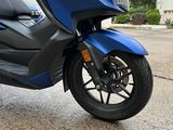 a blue scooter that is parked on the street