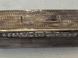 une vieille boîte en argent munie d'une poignée en métal, posée sur une table