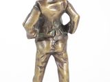 bronze figurine of a boy with a hat and jeans