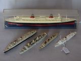 three model ships in a display case on a table