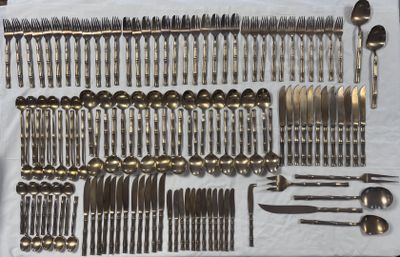 a lot of silverware on a table with a white table cloth