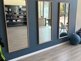 une photo d'une salle de sport avec des miroirs aux murs
