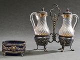 deux vases en argent et en verre et un bol posés sur une table