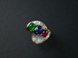 a close up of a ring with multi colored stones on a black surface