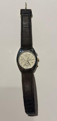 une montre posée sur une surface blanche