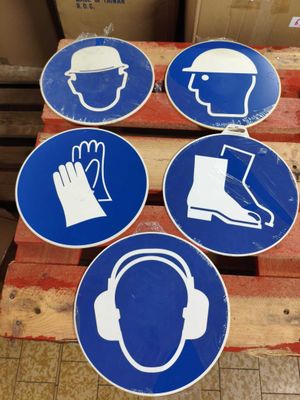 four blue and white signs on a pallet in a warehouse