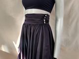 un mannequin vêtu d'un haut noir et d'une jupe violette