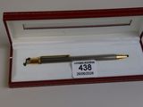 un stylo dans une boîte sur laquelle est apposée une étiquette de prix