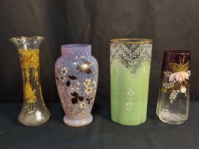 quatre vases de couleurs différentes posés les uns à côté des autres sur une table