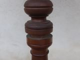 a tall wooden table with a vase on top of it