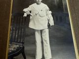 an old photo of a young boy in a sailor ' s uniform