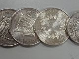 six quarters of silver coins are arranged in a row on a white surface