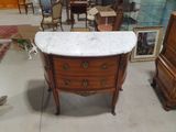 a marble top dresser in the middle of a room
